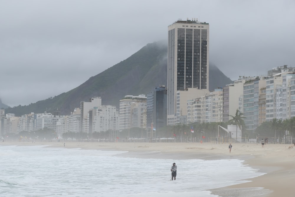 a man standing on a beach next to the ocean