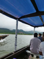 Travelers enjoying a peaceful boat ride on a misty lake in Northeast Shillong.