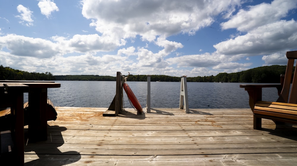 a wooden dock with two benches and a railing