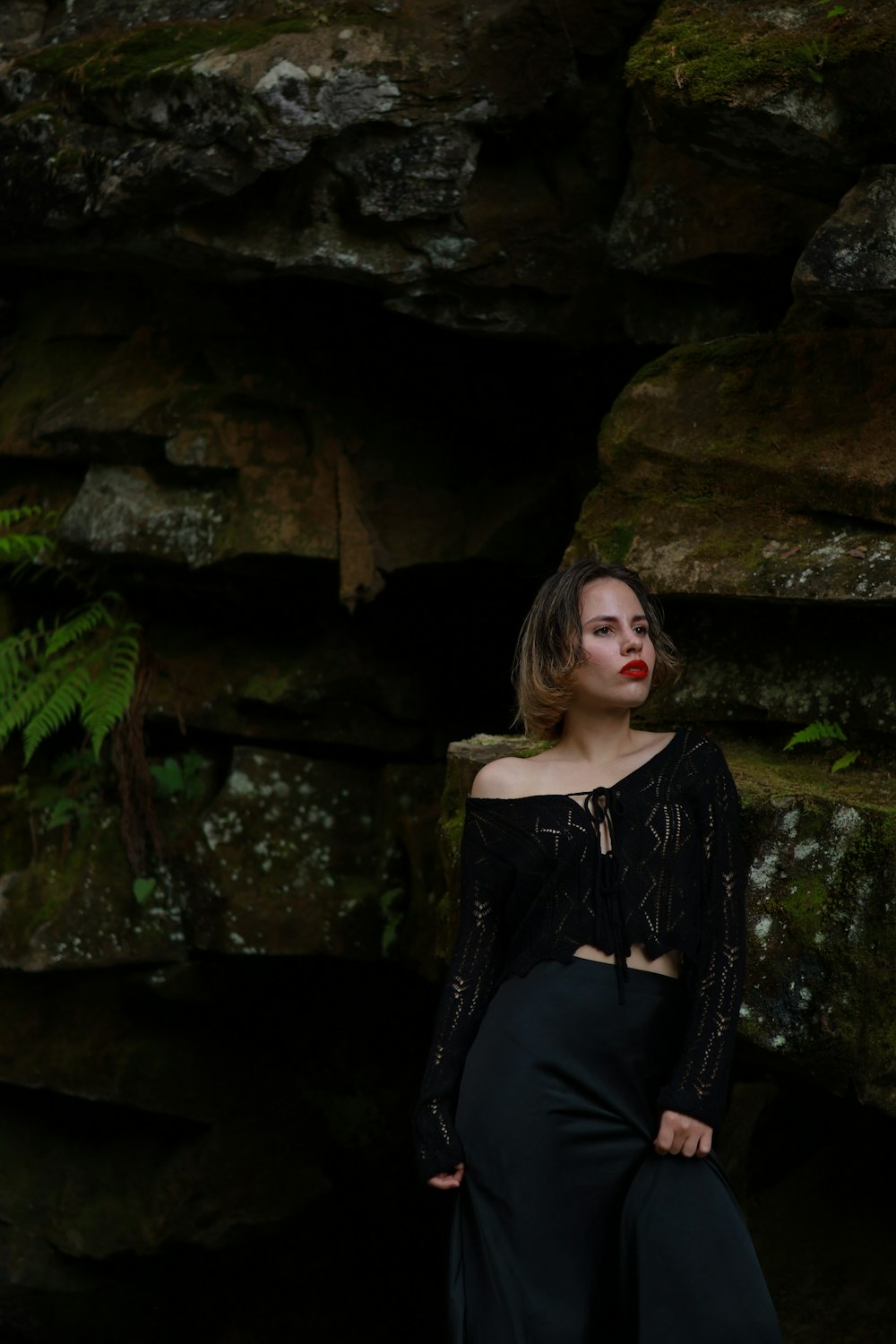 a woman standing in front of a rock formation