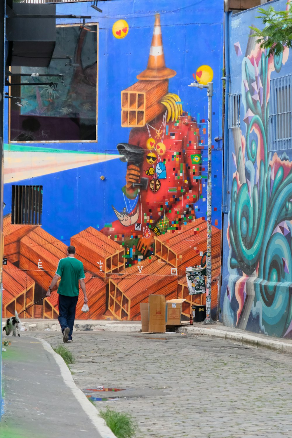 a man walking down a street past a colorful wall