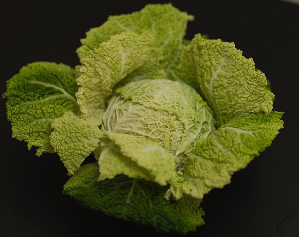 a head of cabbage on a black surface