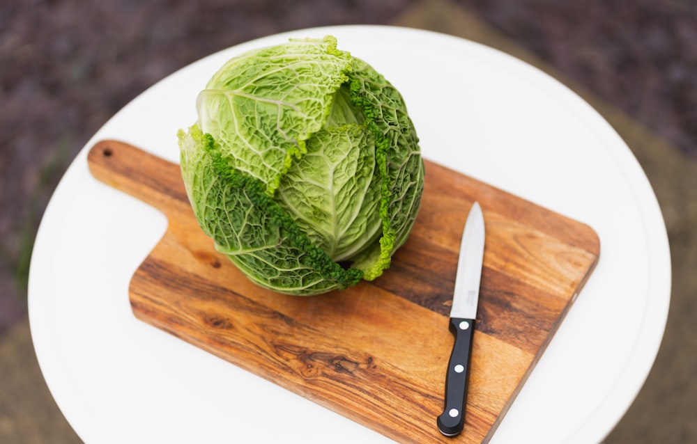 a head of cabbage on a cutting board with a knife