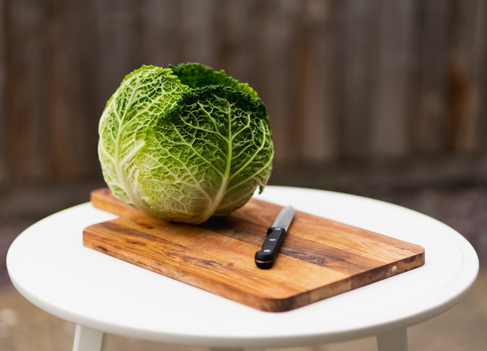 a head of cabbage on a cutting board with a knife