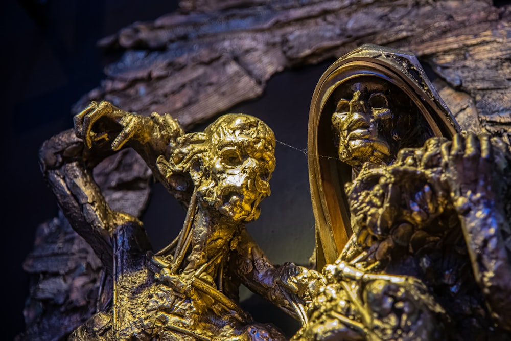 a gold statue of a man and a woman in front of a mirror