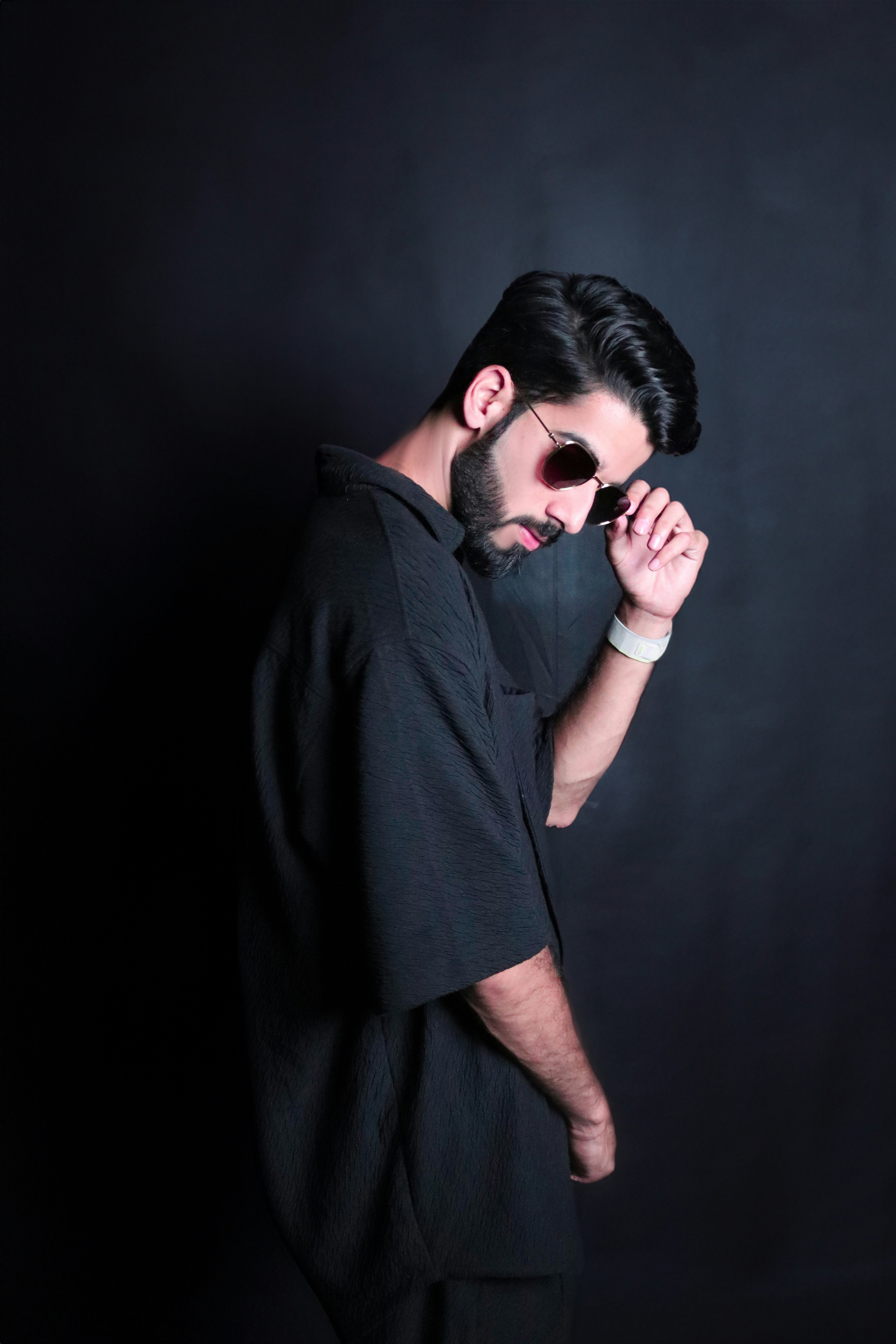 Un hombre con camisa negra y gafas de sol