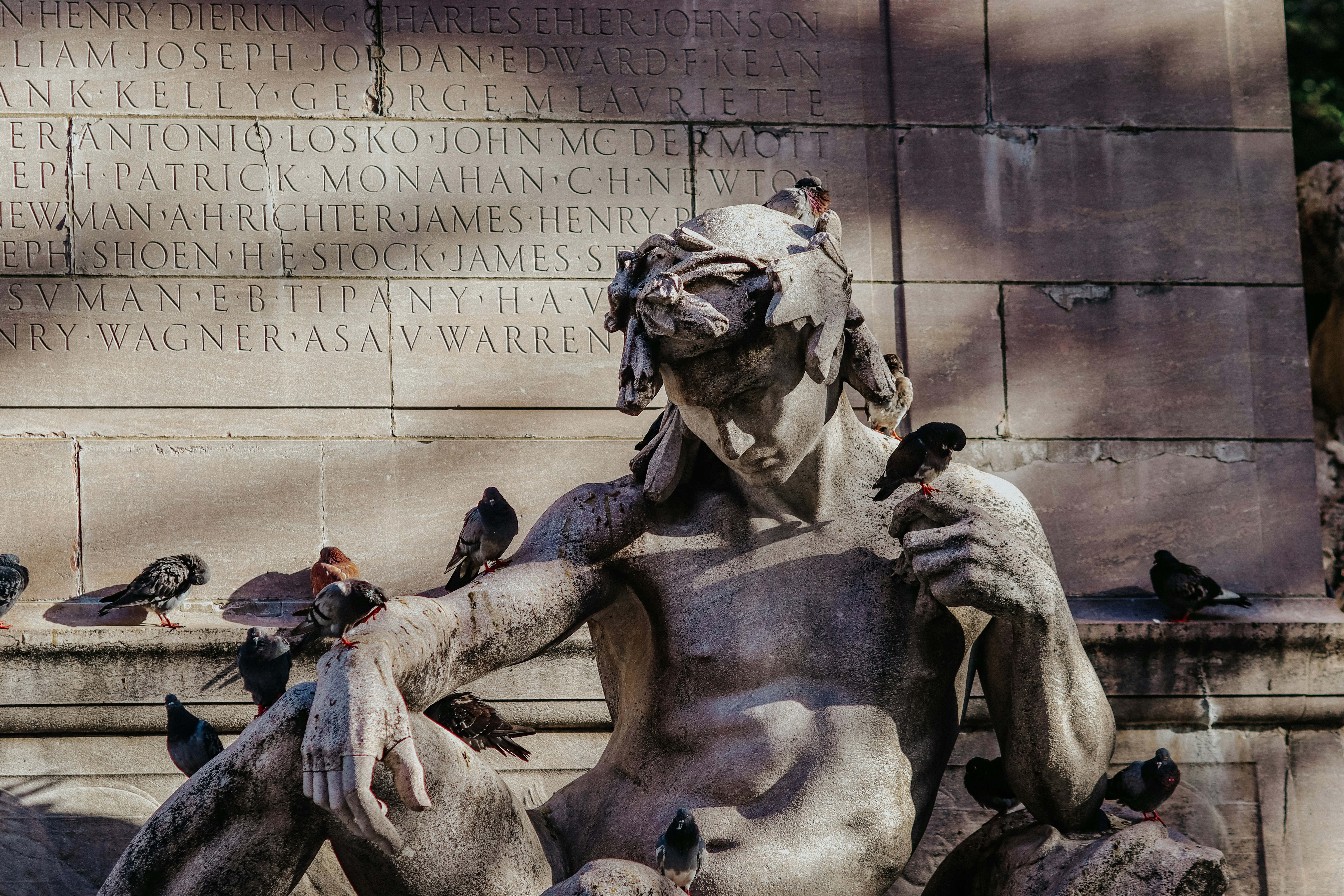 a statue of a man surrounded by pigeons