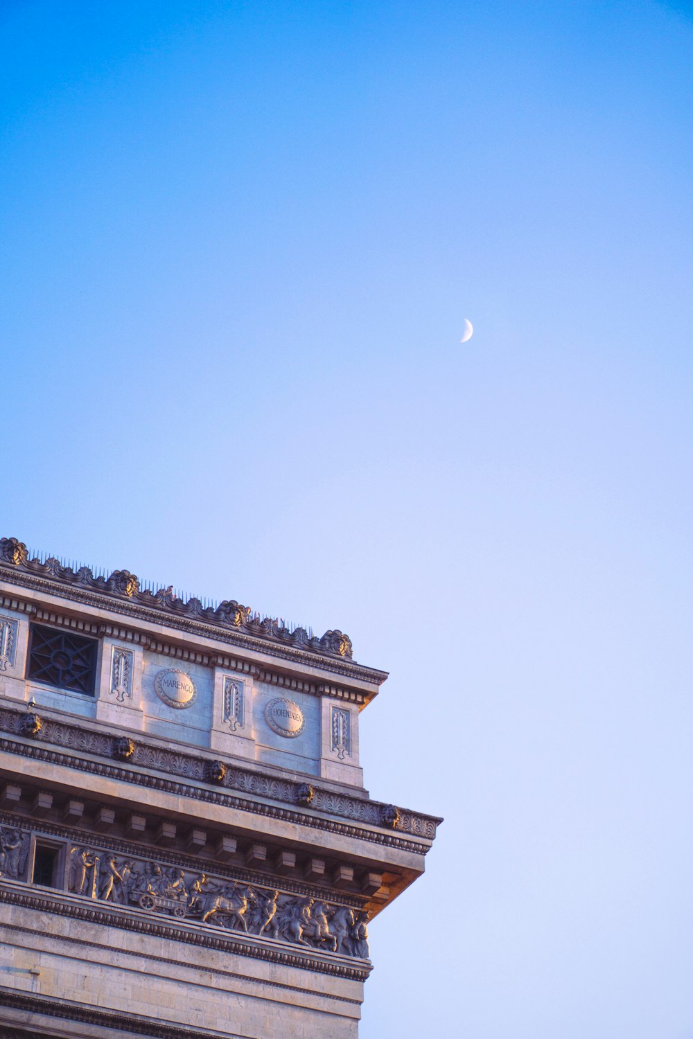 a clock tower with a half moon in the sky