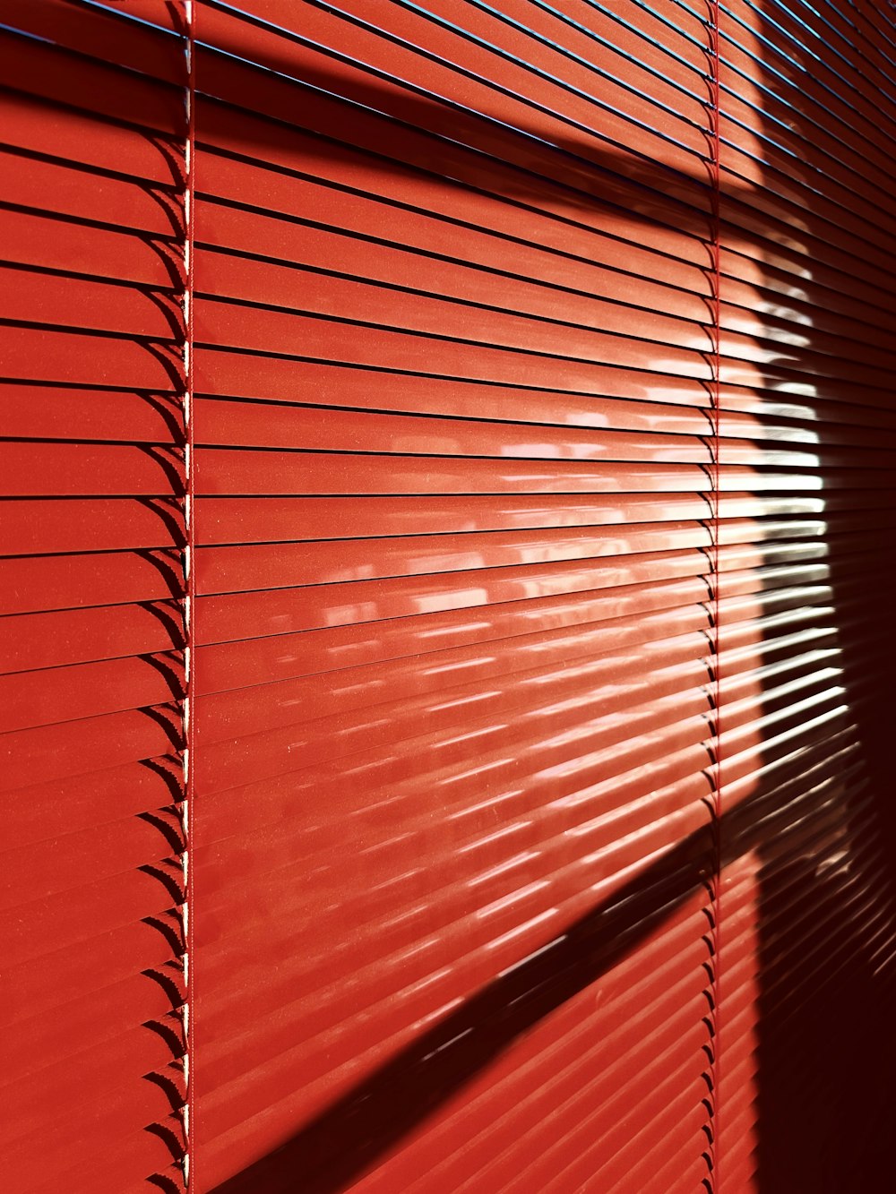 the shadow of a person on a red wall