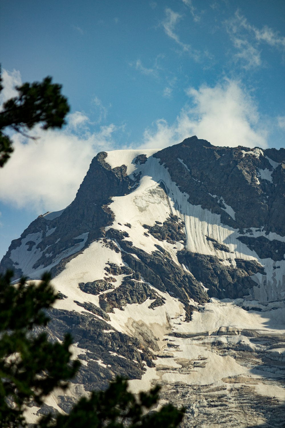 a large mountain covered in snow under a blue sky