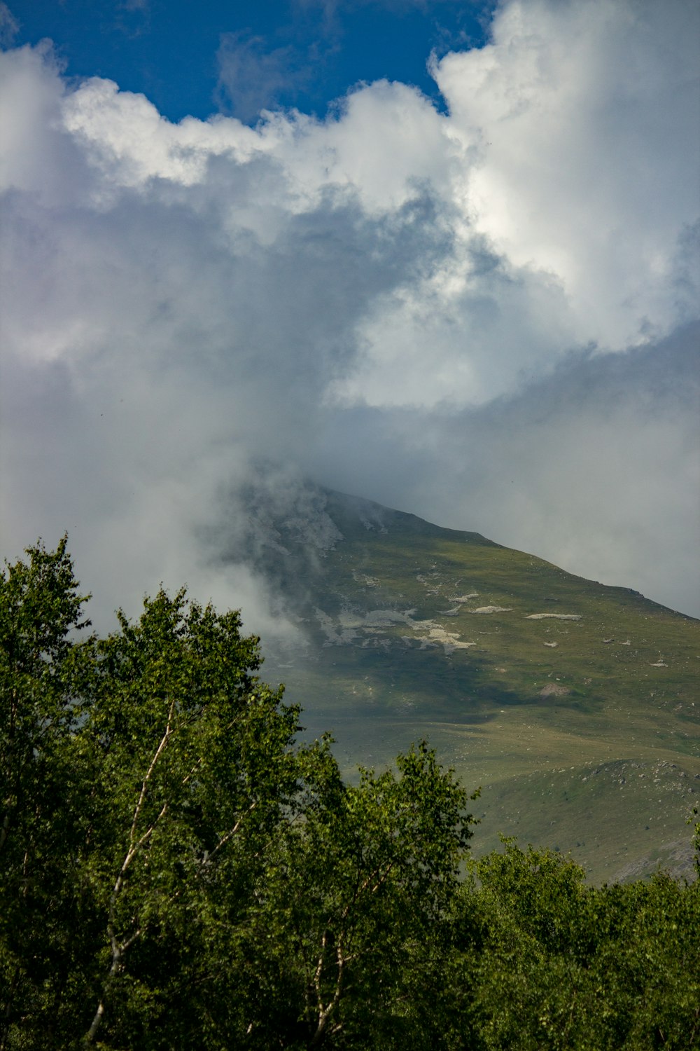 a very tall mountain with some clouds in the sky