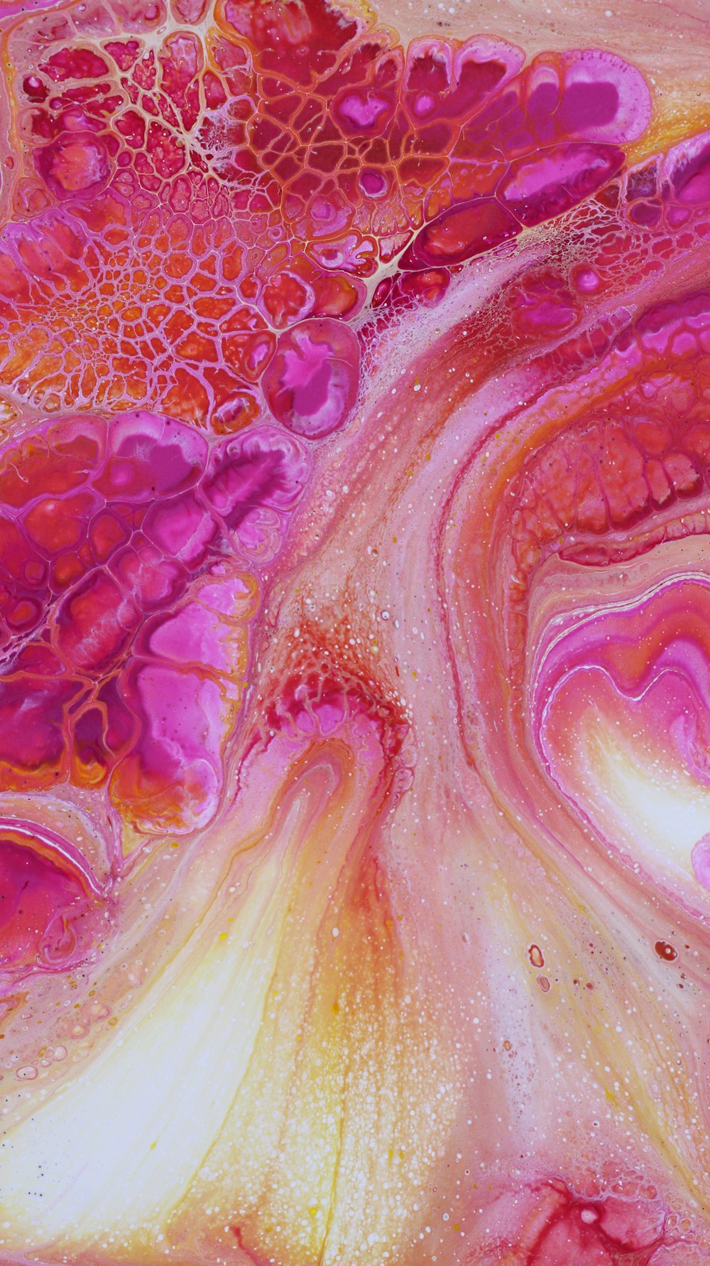 a close up of a pink and yellow fluid painting