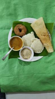 Close-up of freshly cooked vada and pongal served on a banana leaf.