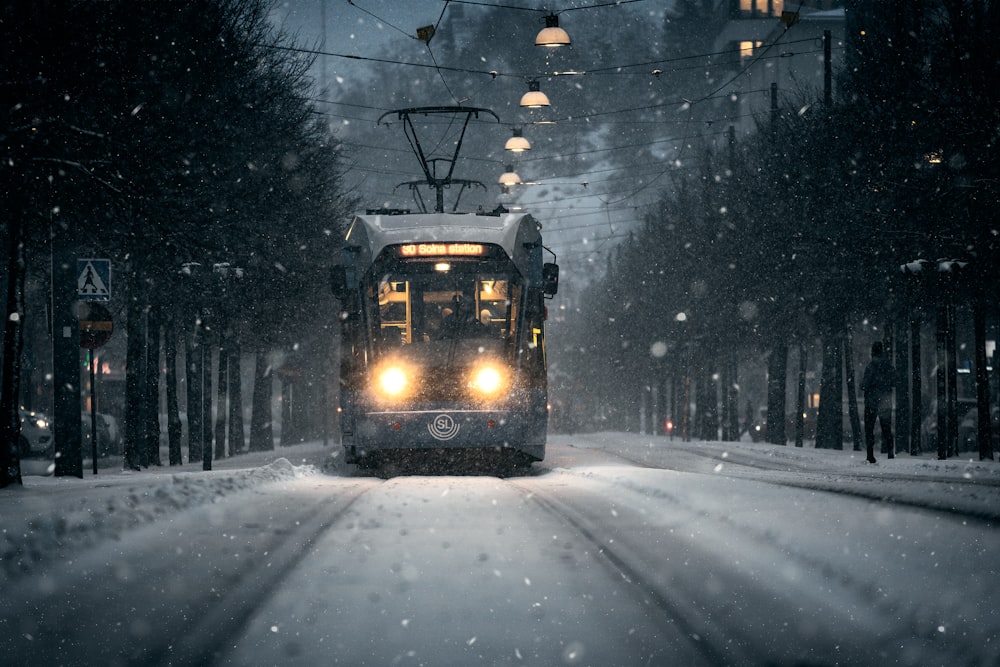 a trolley car traveling down a snow covered street