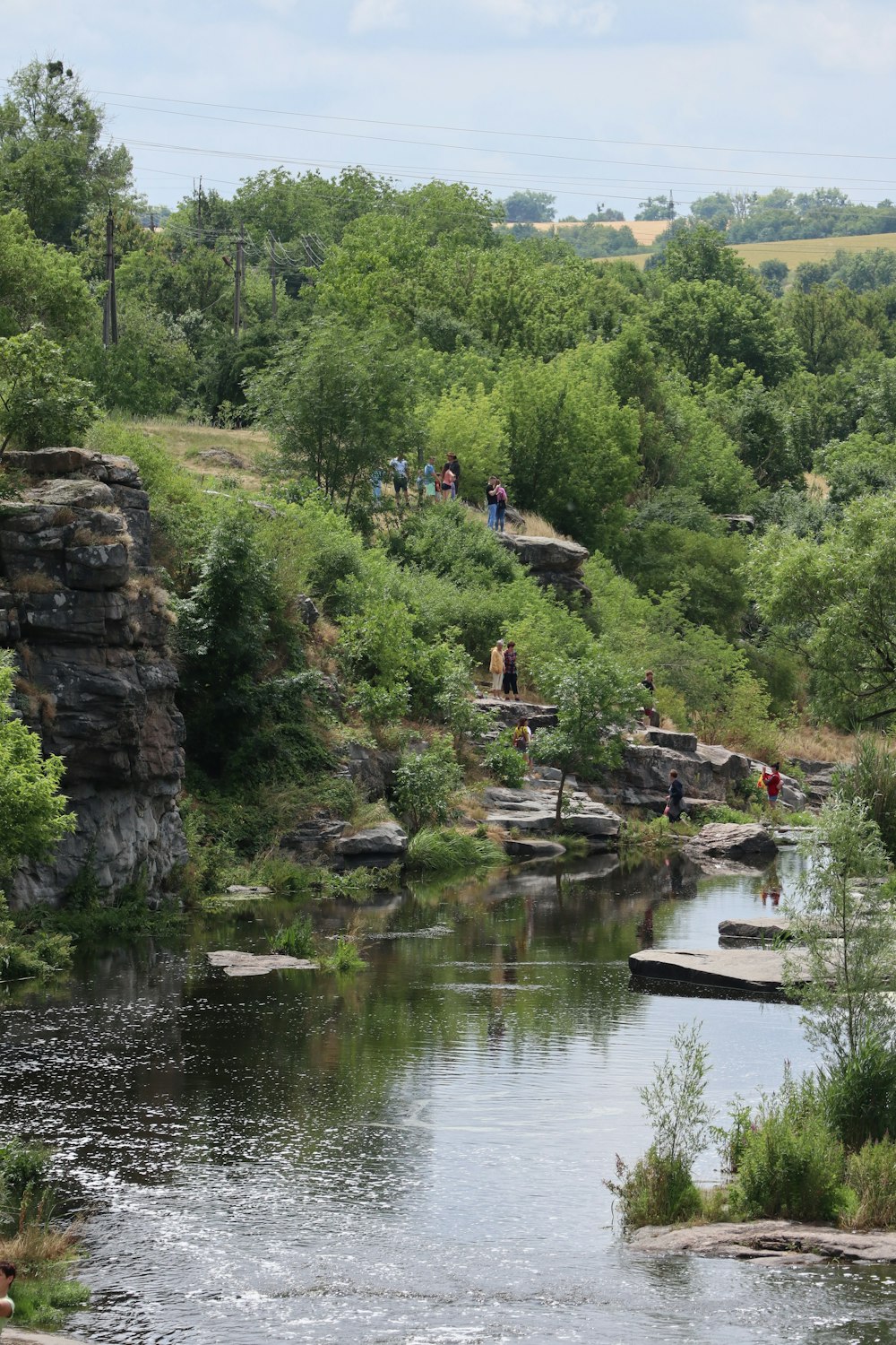 a group of people standing on the side of a river