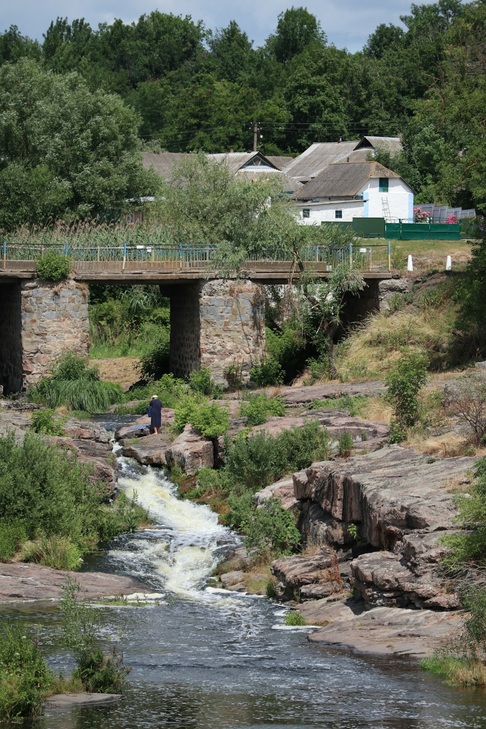 a man standing on a bridge over a river