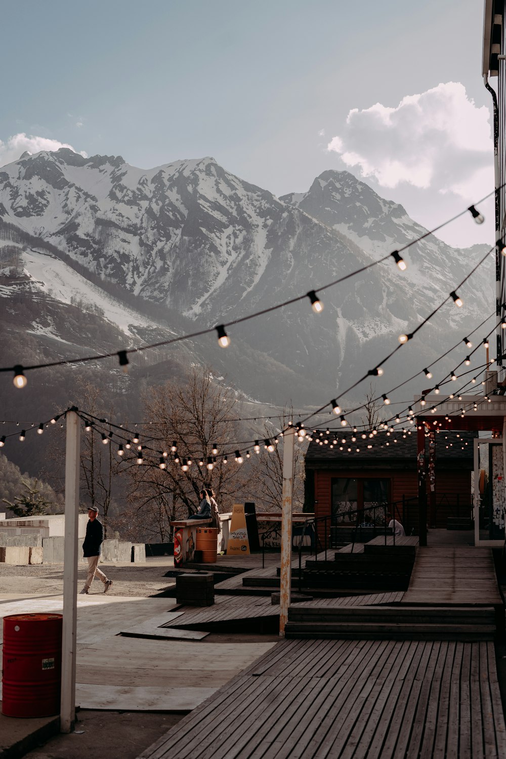a wooden deck with string lights and mountains in the background