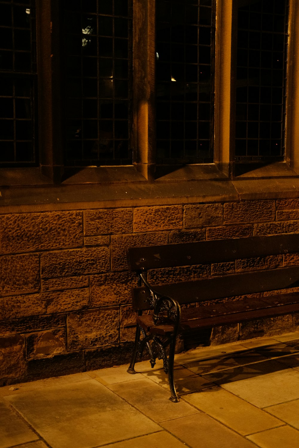 a bench sitting in front of a brick building