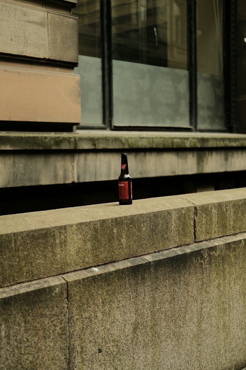 a small bottle sitting on the side of a building