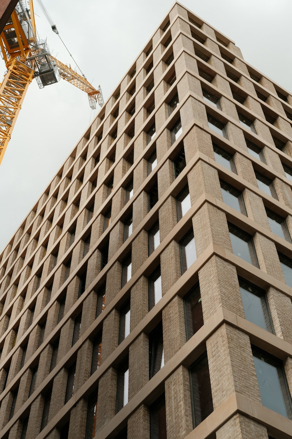 a crane is on the side of a tall building