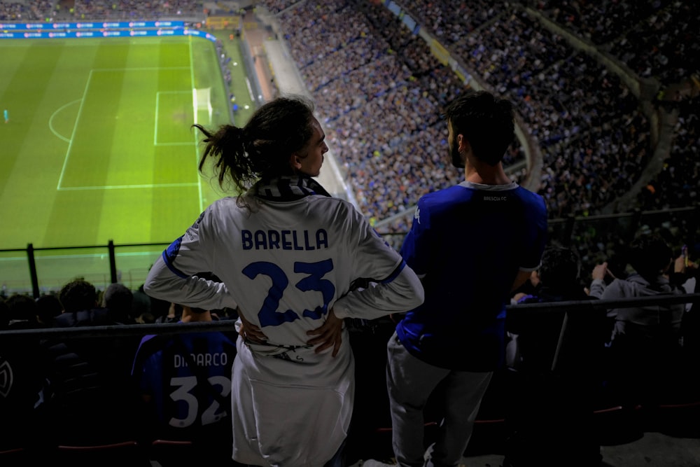 a couple of people that are standing in front of a soccer field