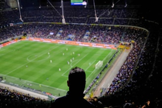 A sleek black and white photo of a football stadium filled with fans, capturing the energy of a Premier League match.