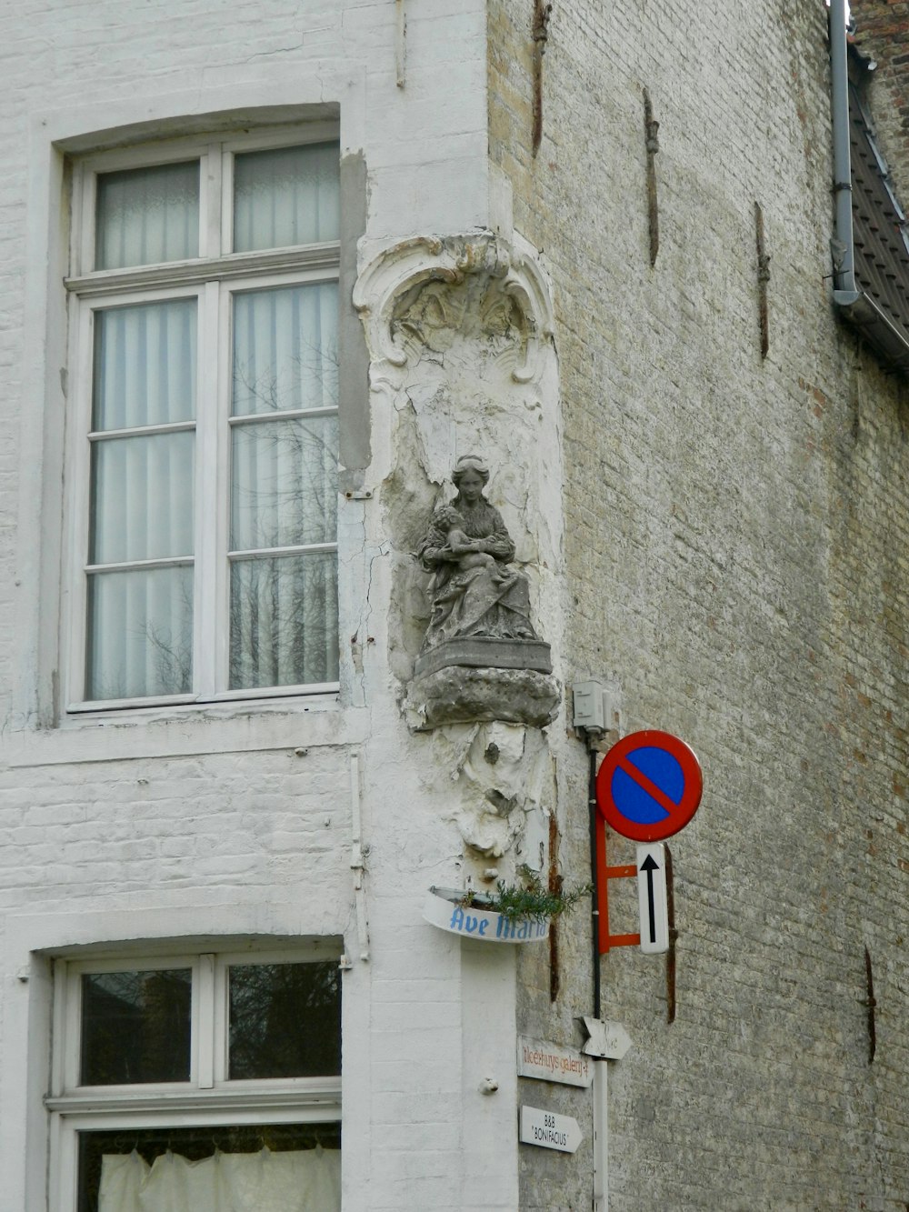 a white building with a red and blue street sign