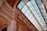 Intricate architectural details of an elegant building with a grand, arched glass roof. The ceiling is finely decorated with ornate moldings and carvings, showcasing a blend of classical and modern design elements.
