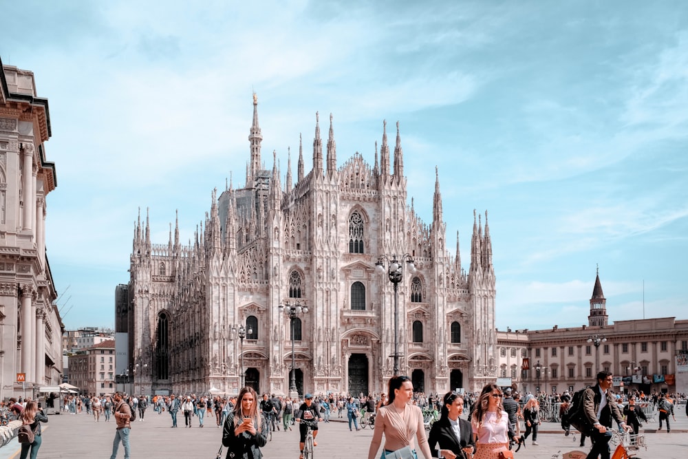 a group of people walking around a large cathedral