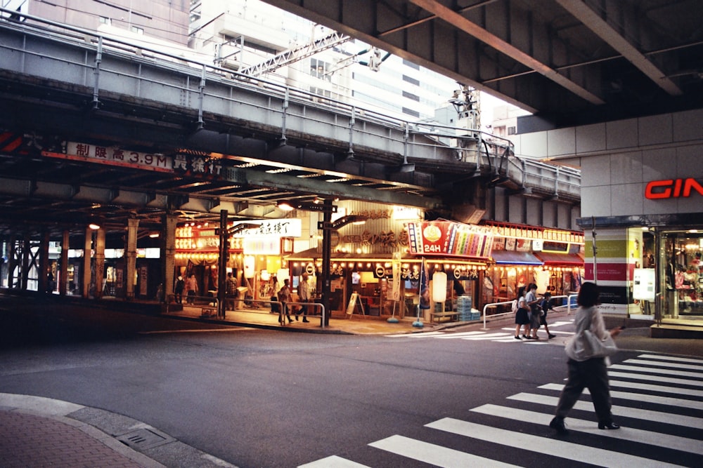 a person crossing a street in front of a building