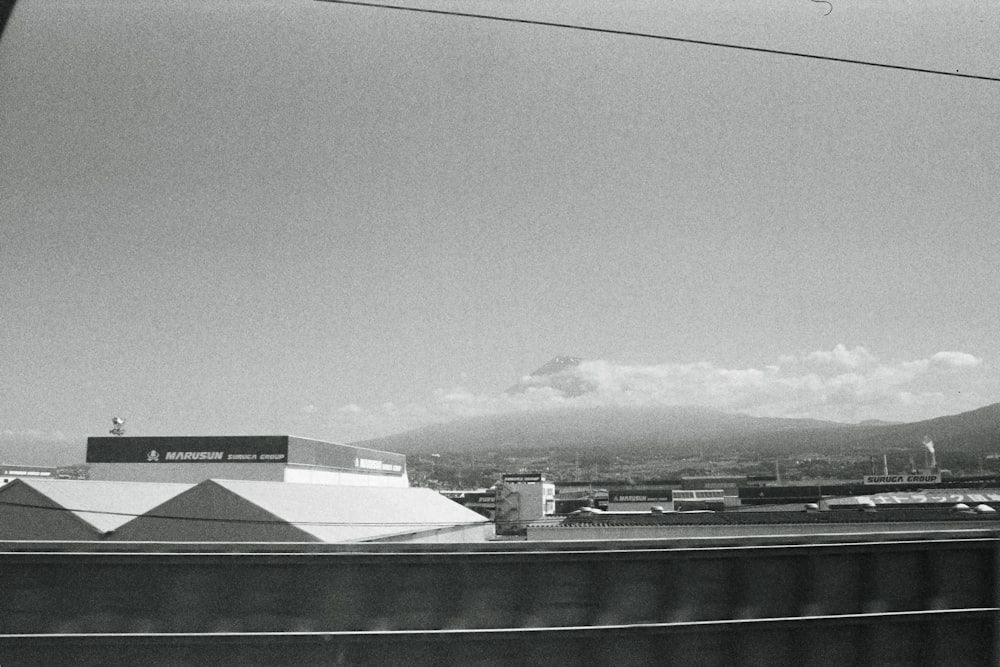 a black and white photo of a city with mountains in the background