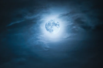 A softly glowing collage of moon phases blending into ethereal clouds and shimmering stars.