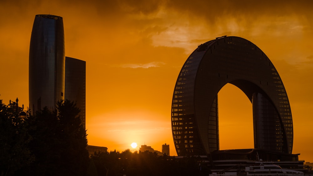 the sun is setting over a city with tall buildings