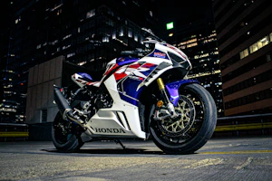 A classic Honda cruiser motorcycle shining under city lights at night