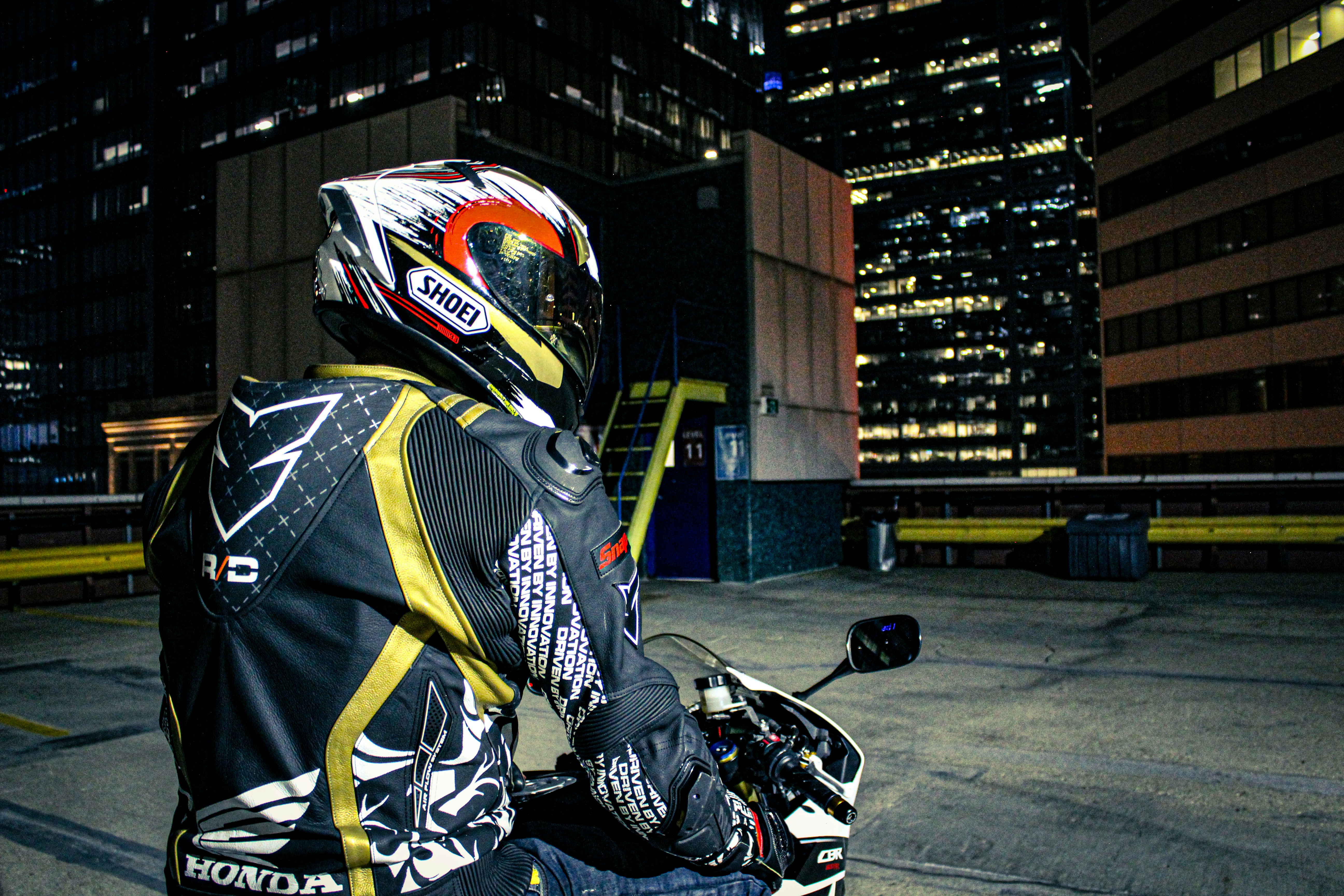 a motorcyclist wearing a black and yellow jacket and helmet