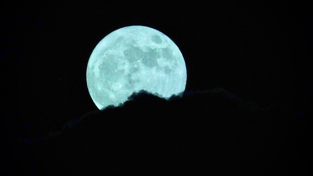 Una luna piena vista attraverso le nuvole nel cielo notturno