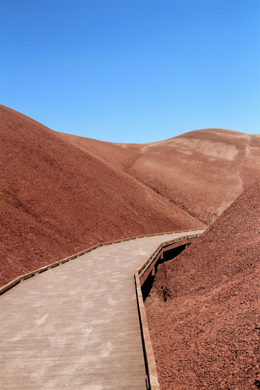 a wooden walkway in the middle of a desert