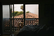 Bright, airy room with traditional Sri Lankan decor and a large window overlooking palm trees.