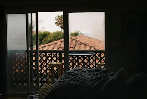 A bright, airy room at Jesolo Resort with a large window overlooking palm trees.