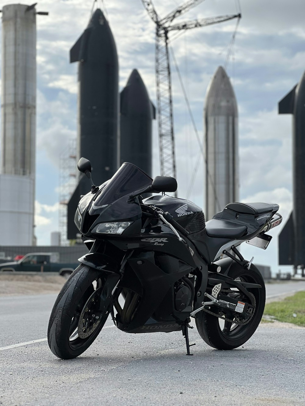 Una motocicleta negra estacionada al costado de la carretera
