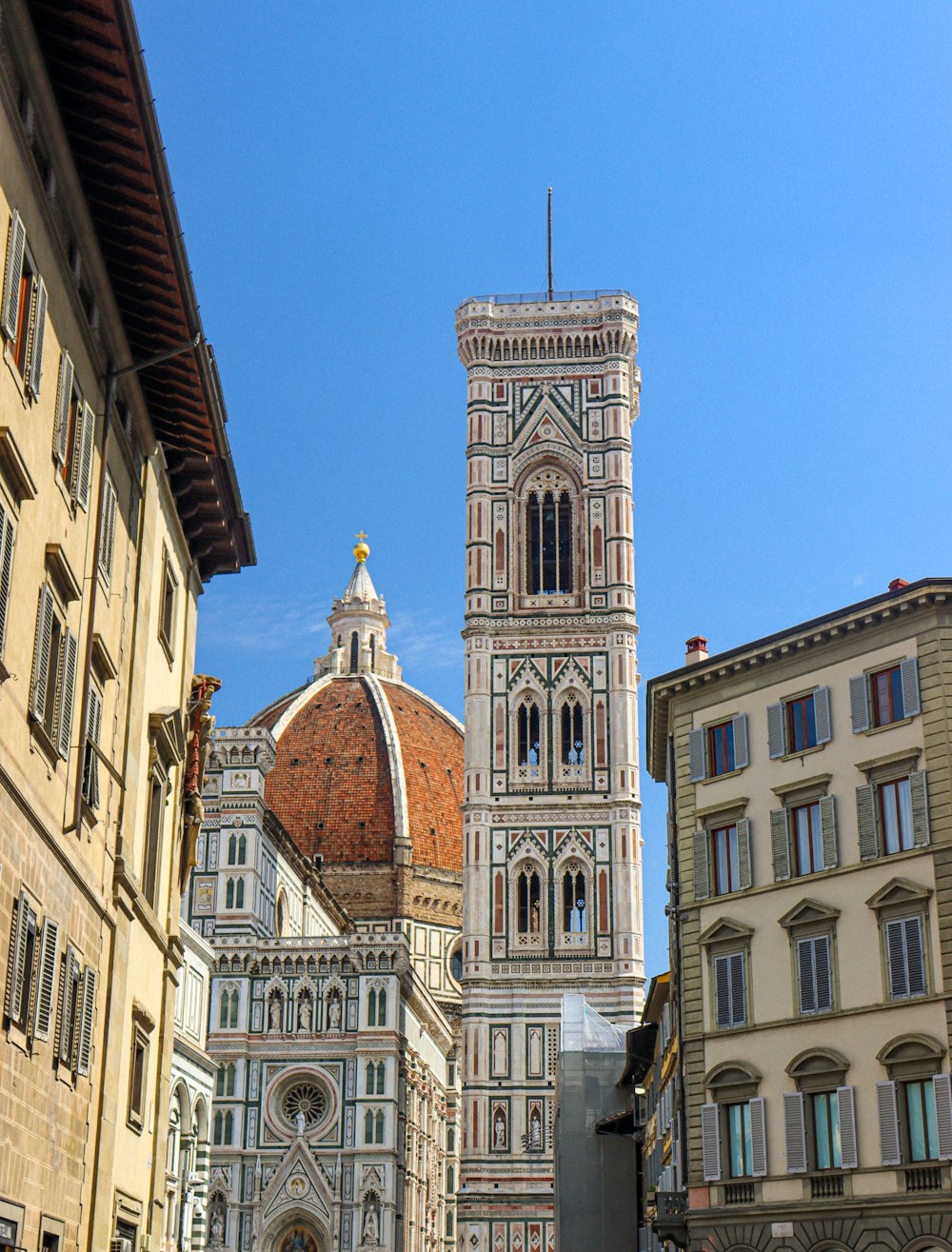 a large cathedral towering over a city next to tall buildings