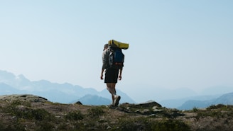 a man with a backpack walking up a hill