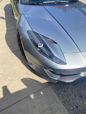 Shiny silver sports car with flawless paint protection film on the front bumper.