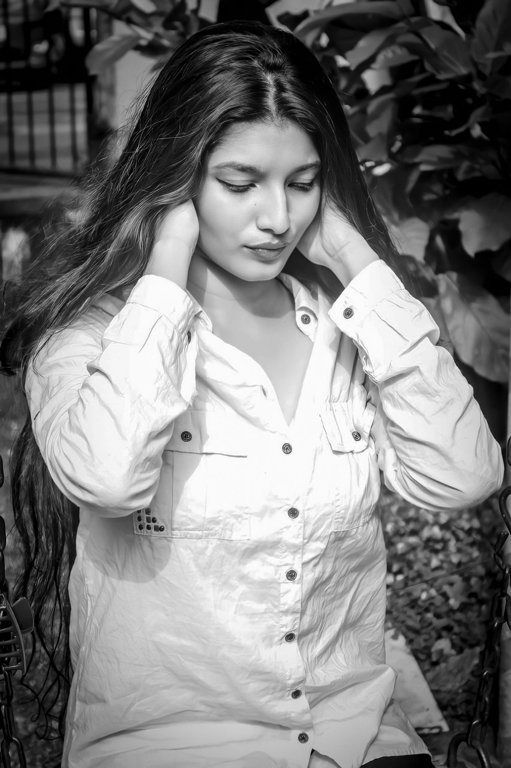 a black and white photo of a woman holding her hair