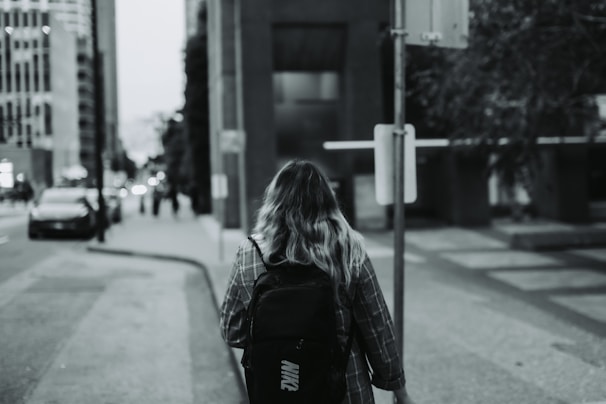 Side view of the backpack worn by a commuter walking through a city street.