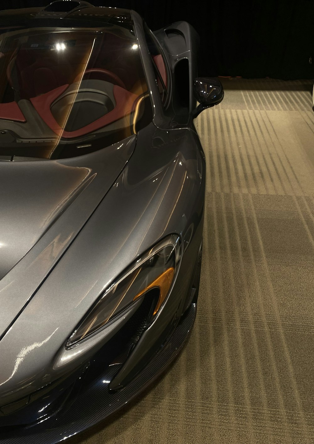 a silver sports car parked in a showroom