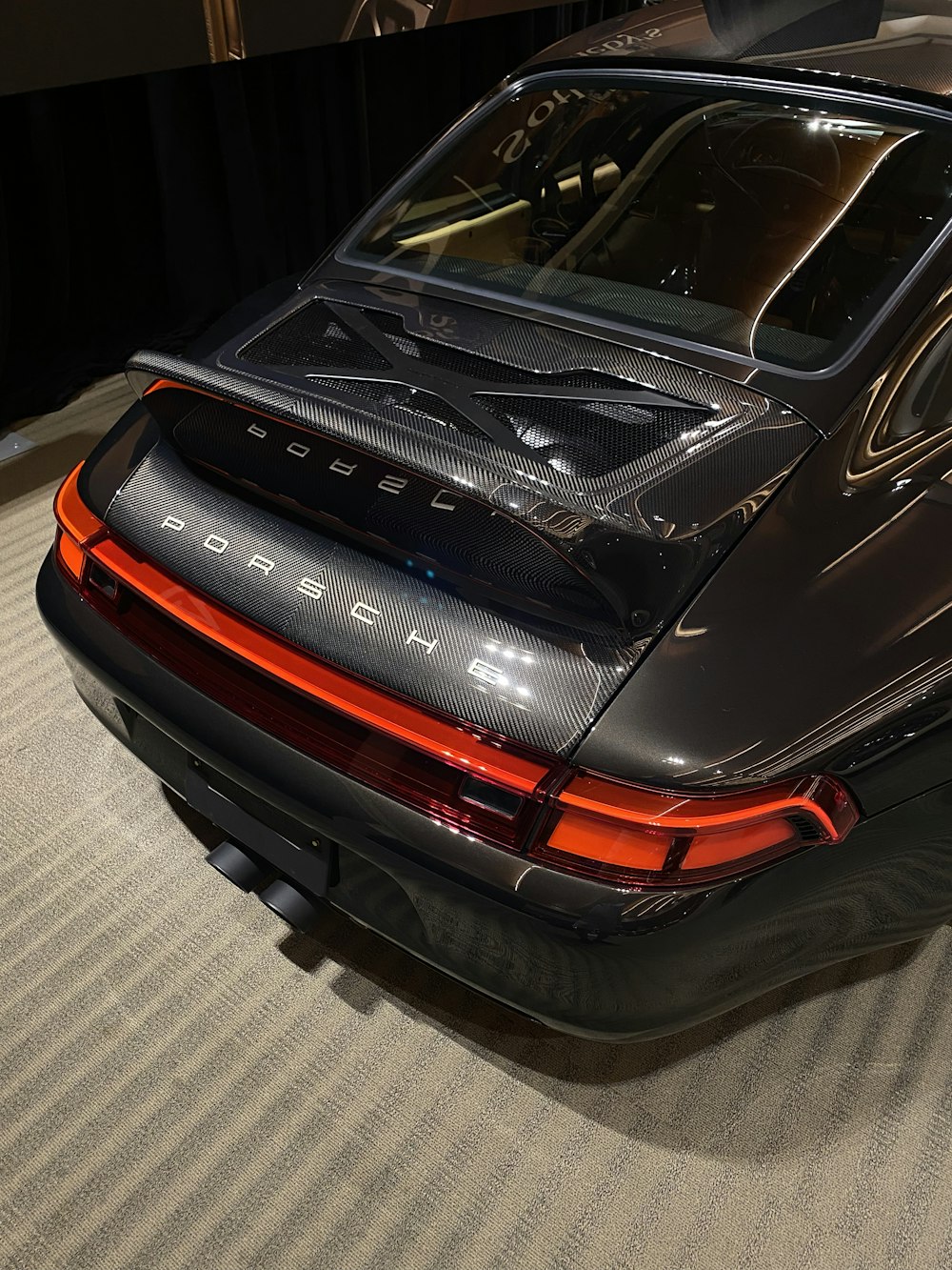 a black porsche parked in a showroom