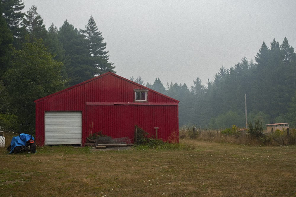 a red barn in a field with a blue backpack