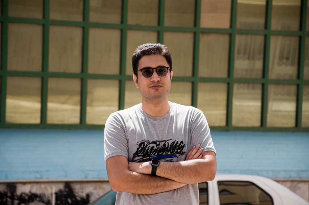 a man standing in front of a building with his arms crossed