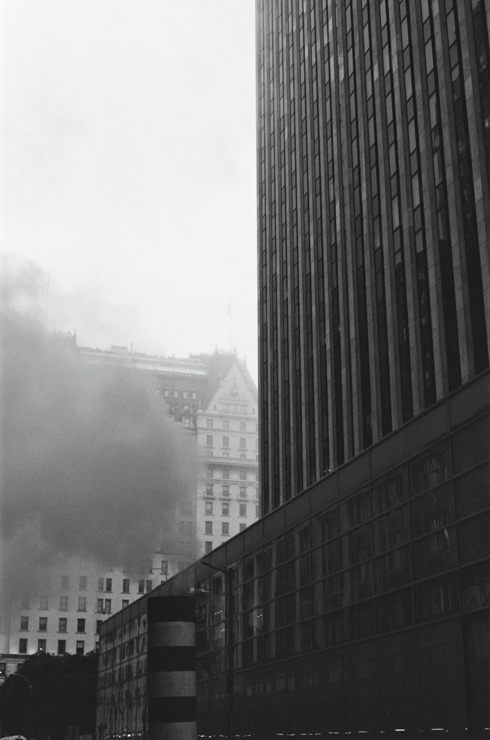 a black and white photo of a building with smoke coming out of it